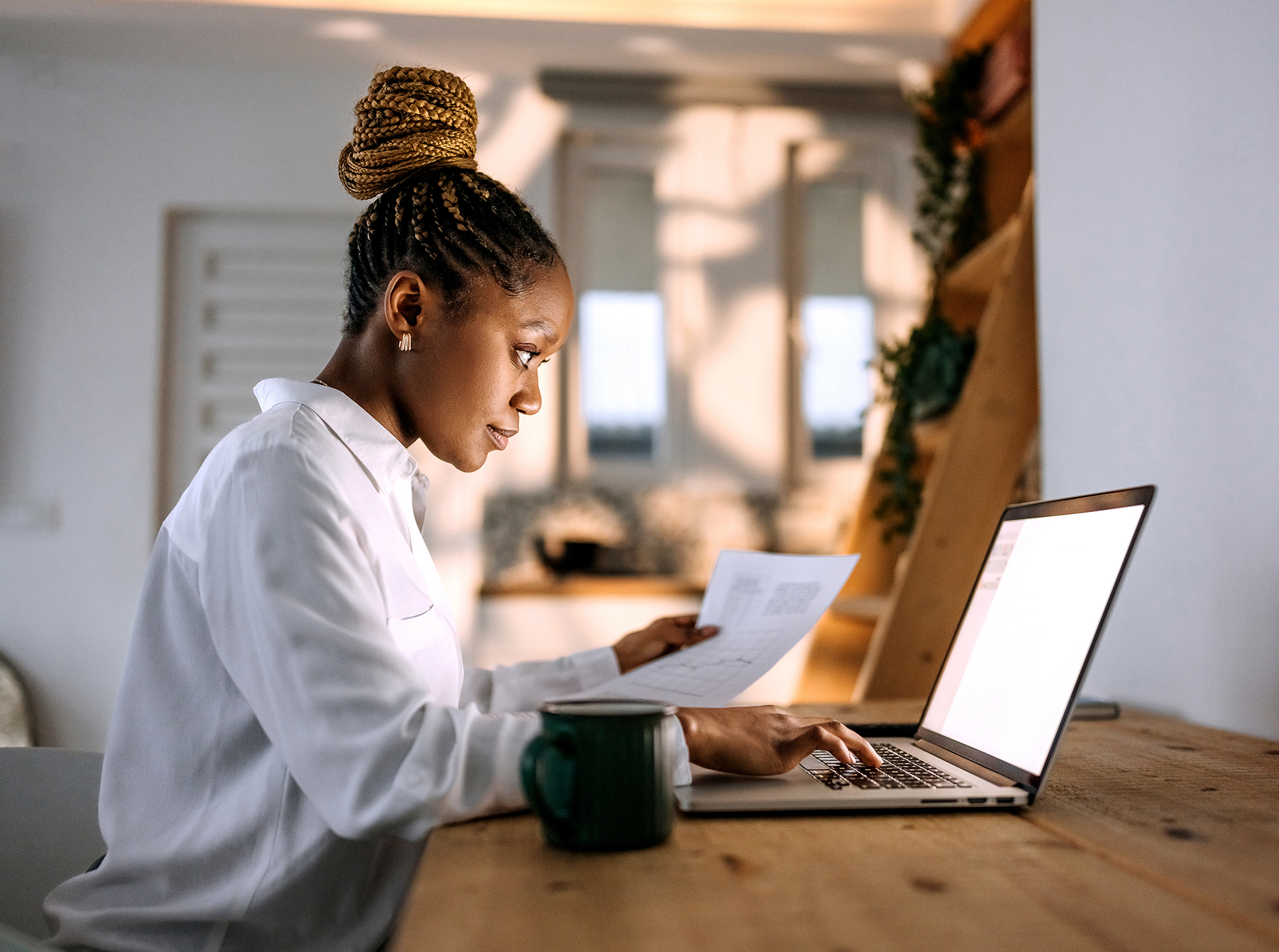 diverse young business woman holding paper staring at laptop
