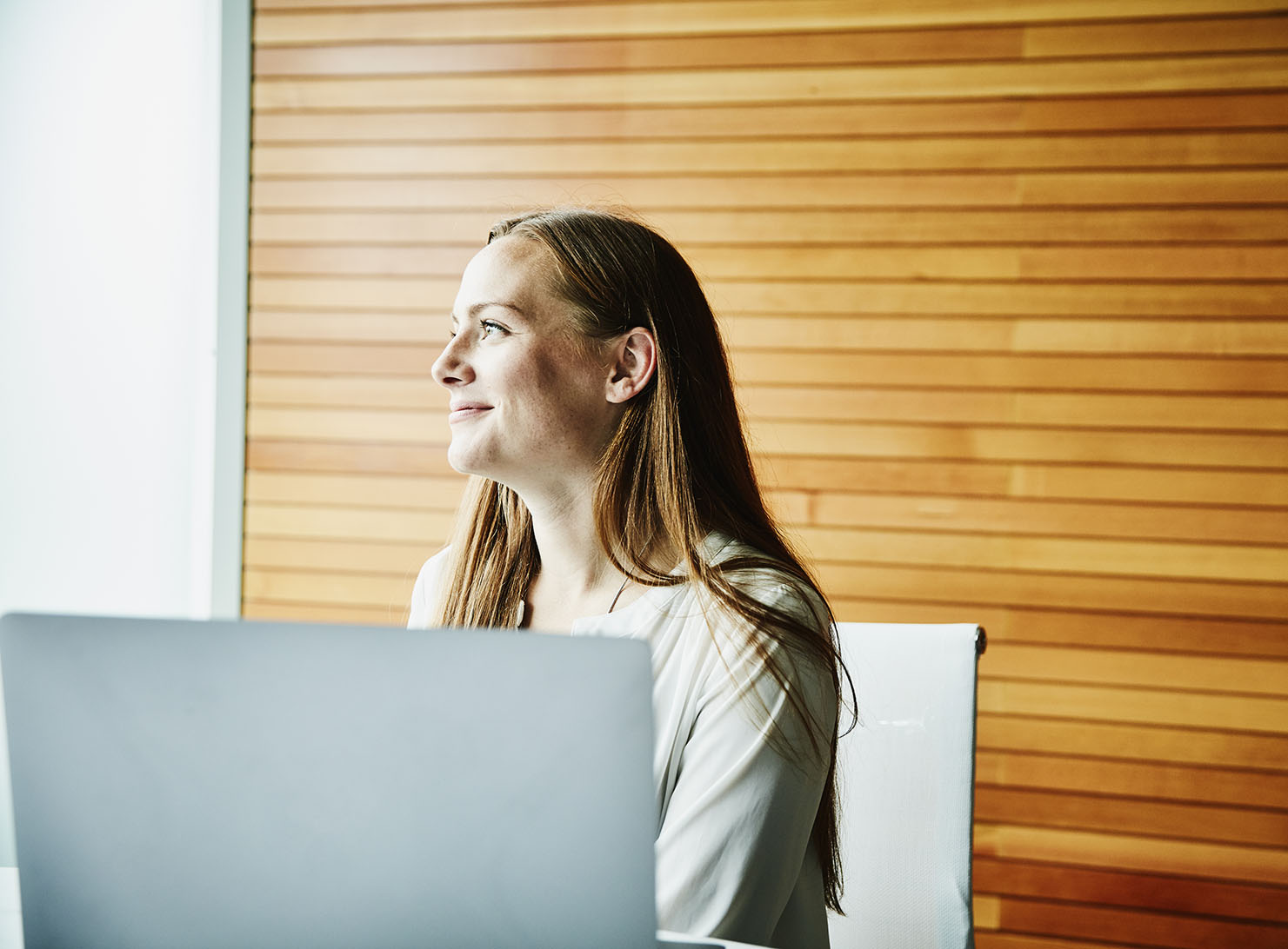 side view of smiling businesswoman working at a computer in office