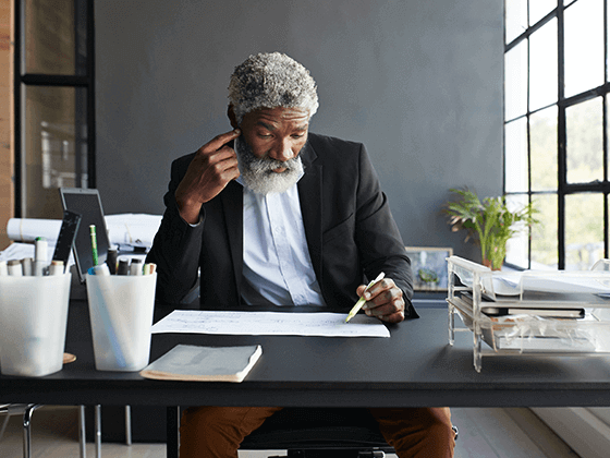 Diverse older business man at desk reading