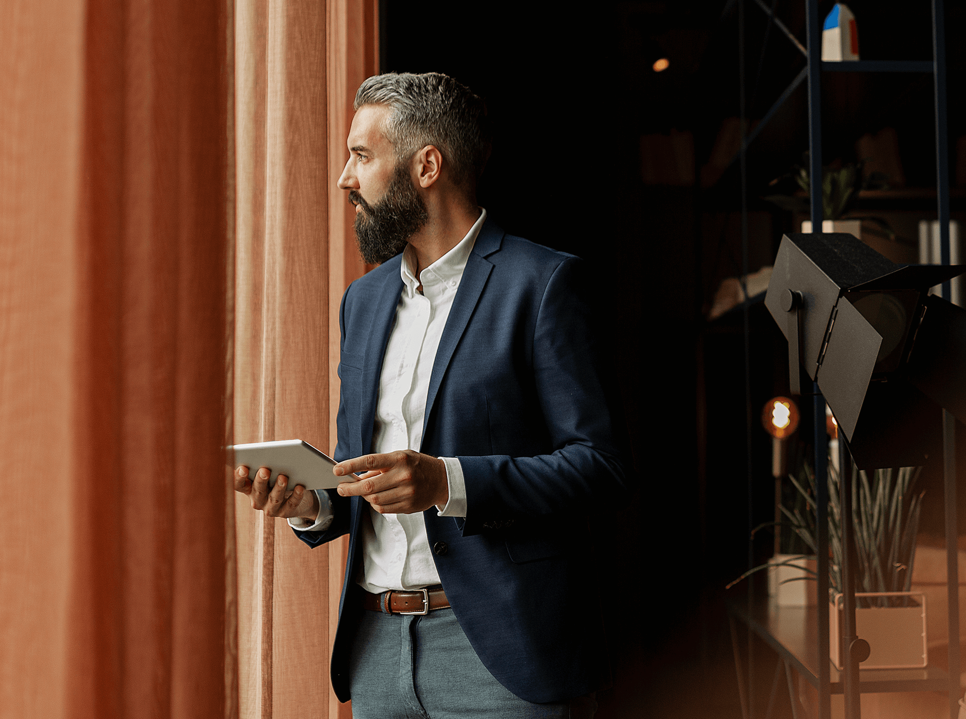 bearded business man standing with electronic tablet in hand